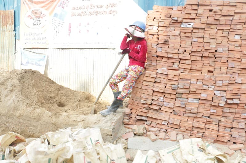 A construction worker leans on a stack of bricks at a Phnom Penh construction site in 2017.